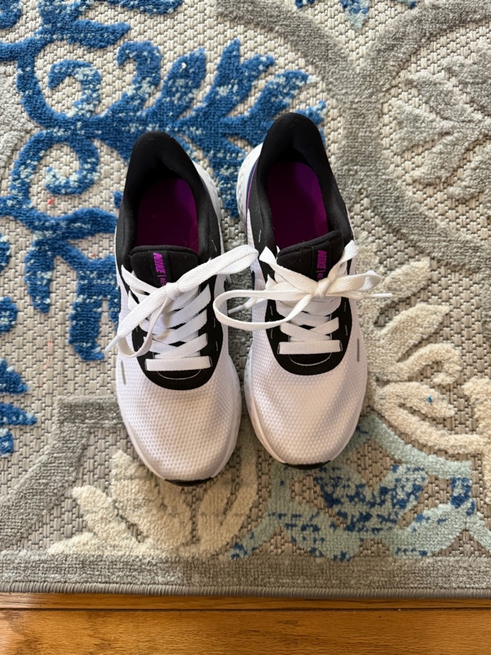 Nike Women’s Revolution sneakers in white, black, blue, and purple